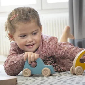 petite fille jouant avec la petite voiture en bois Aline - Fabrication française par Idébois Créations